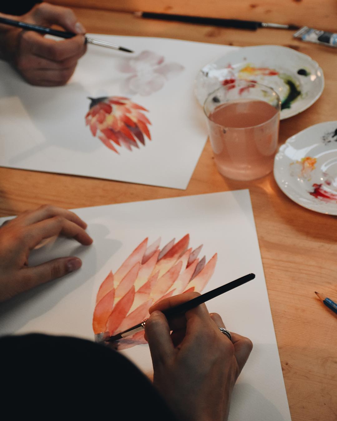 Senhora a pintar em aguarela uma flor, em workshop da Terrárea de pintura em aguarela de flores